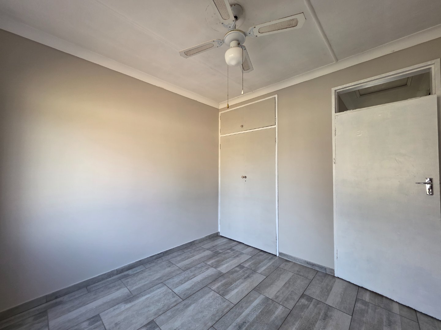 BEDROOM 1 WITH FAN AND CUPBOARDS